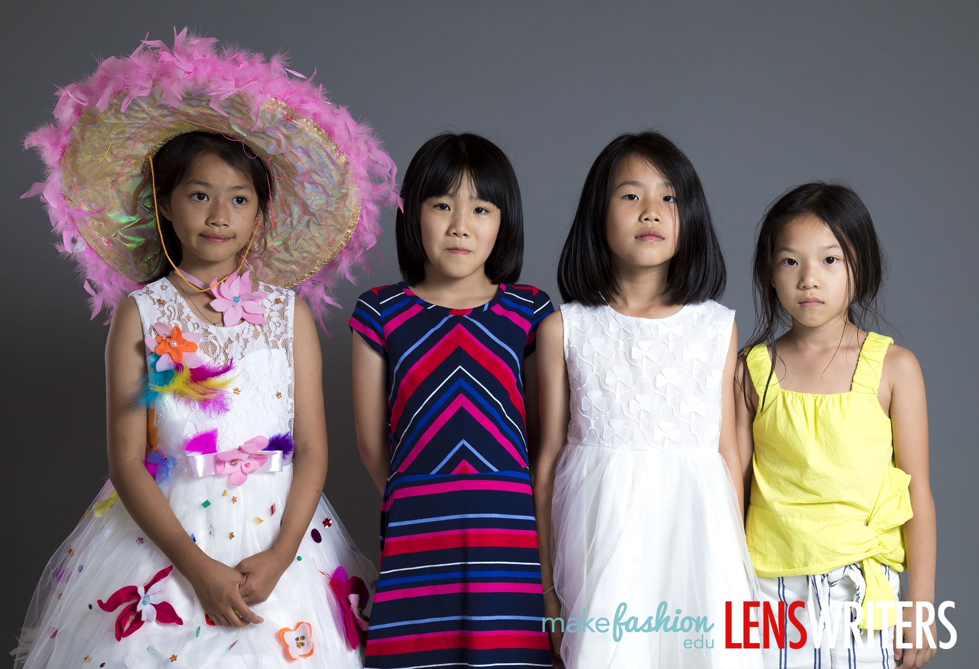 Four students pose together, one wearing a feathered hat and floral quinceañera dress