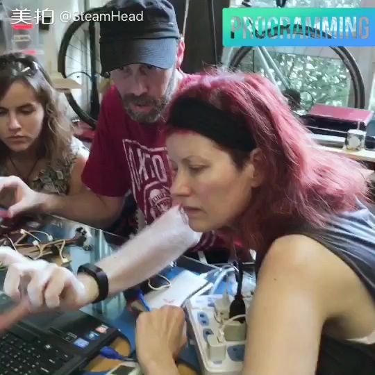 Anina Net working at a laptop with two other makers during a programming session