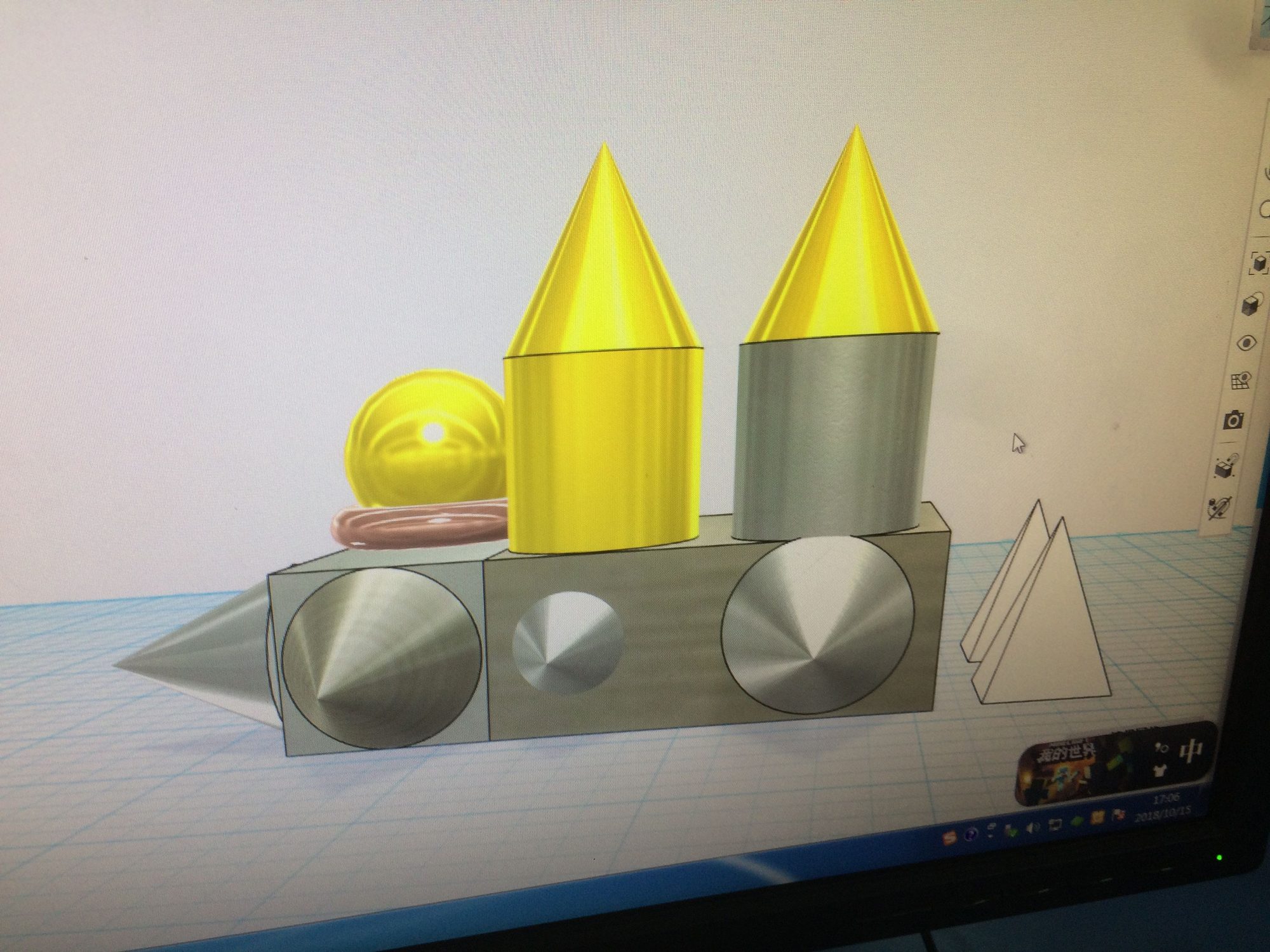 Monitor showing yellow and silver 3D shapes in design software