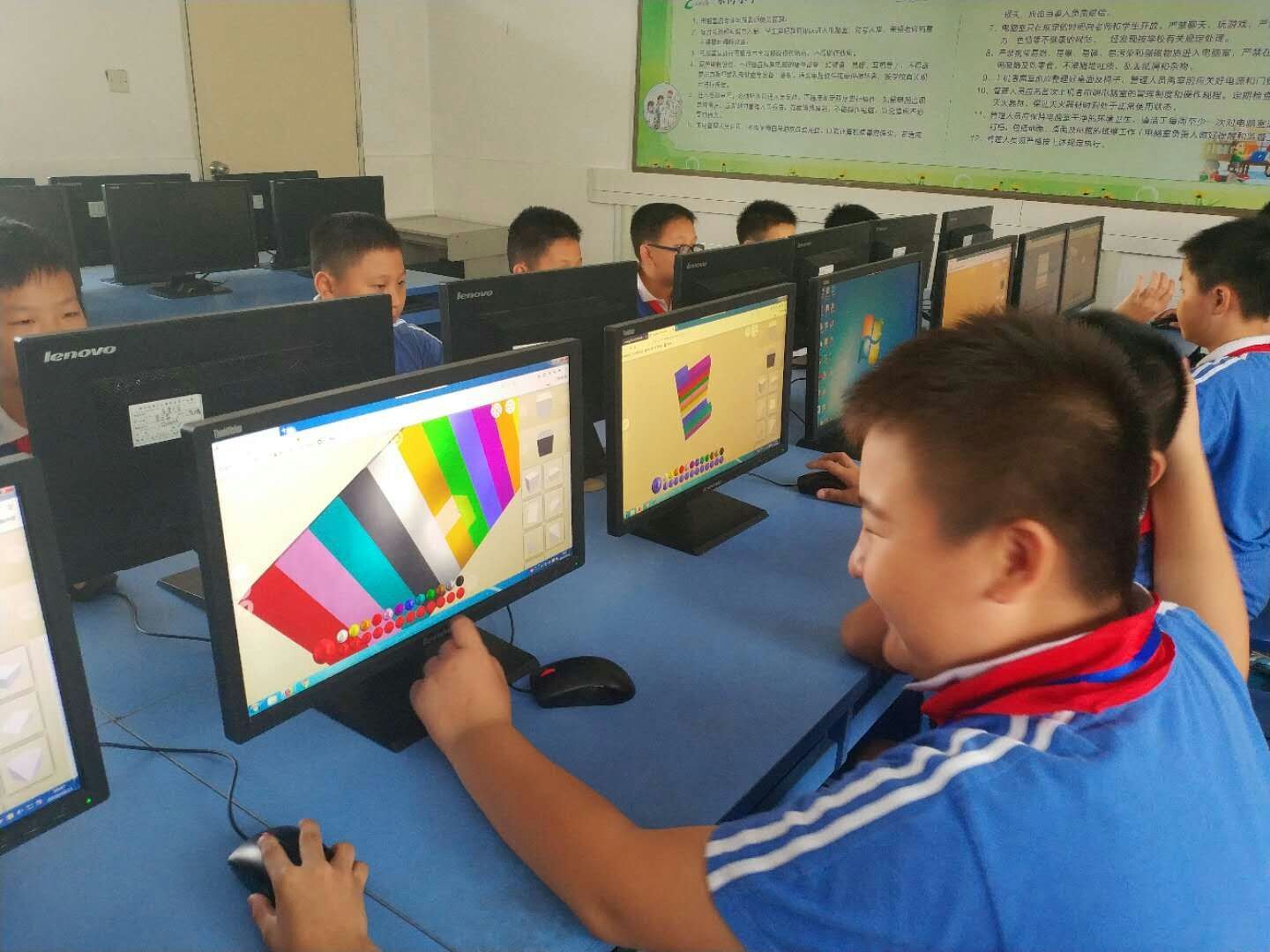 Students using 3D design software at computers in a classroom