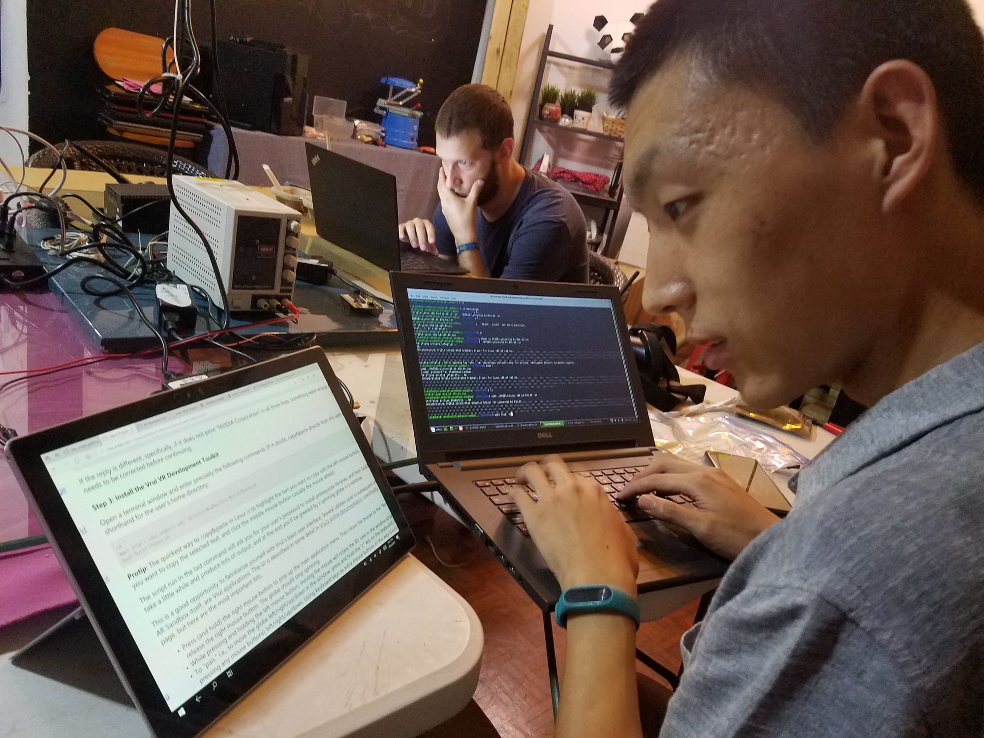 Two makers troubleshooting laptops during a software setup session