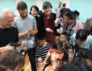 Mitch Altman leading a recycled bottle craft workshop with students