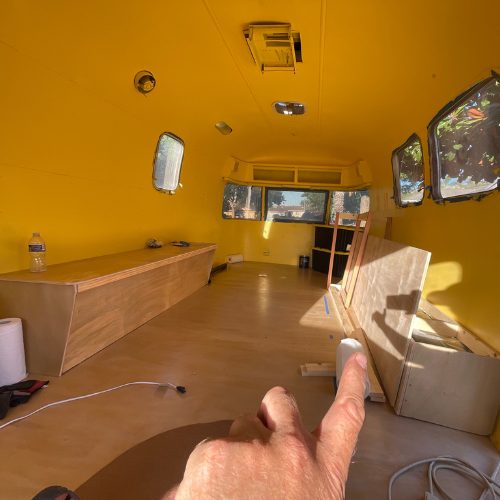 Mobile Makerspace chapter 11: interior of the yellow-painted Airstream with new plywood flooring and cabinetry