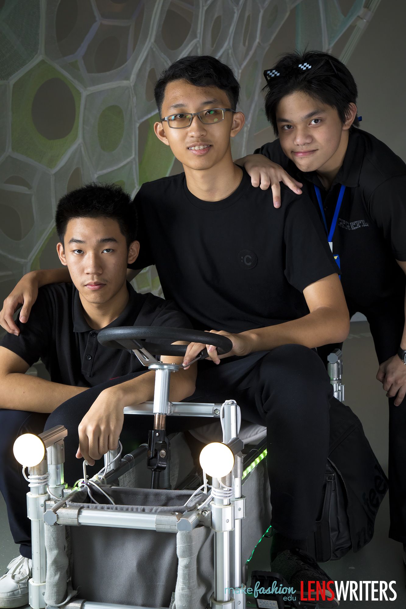 Student designers backstage with wearable bike machine fitted with white spherical LED lights