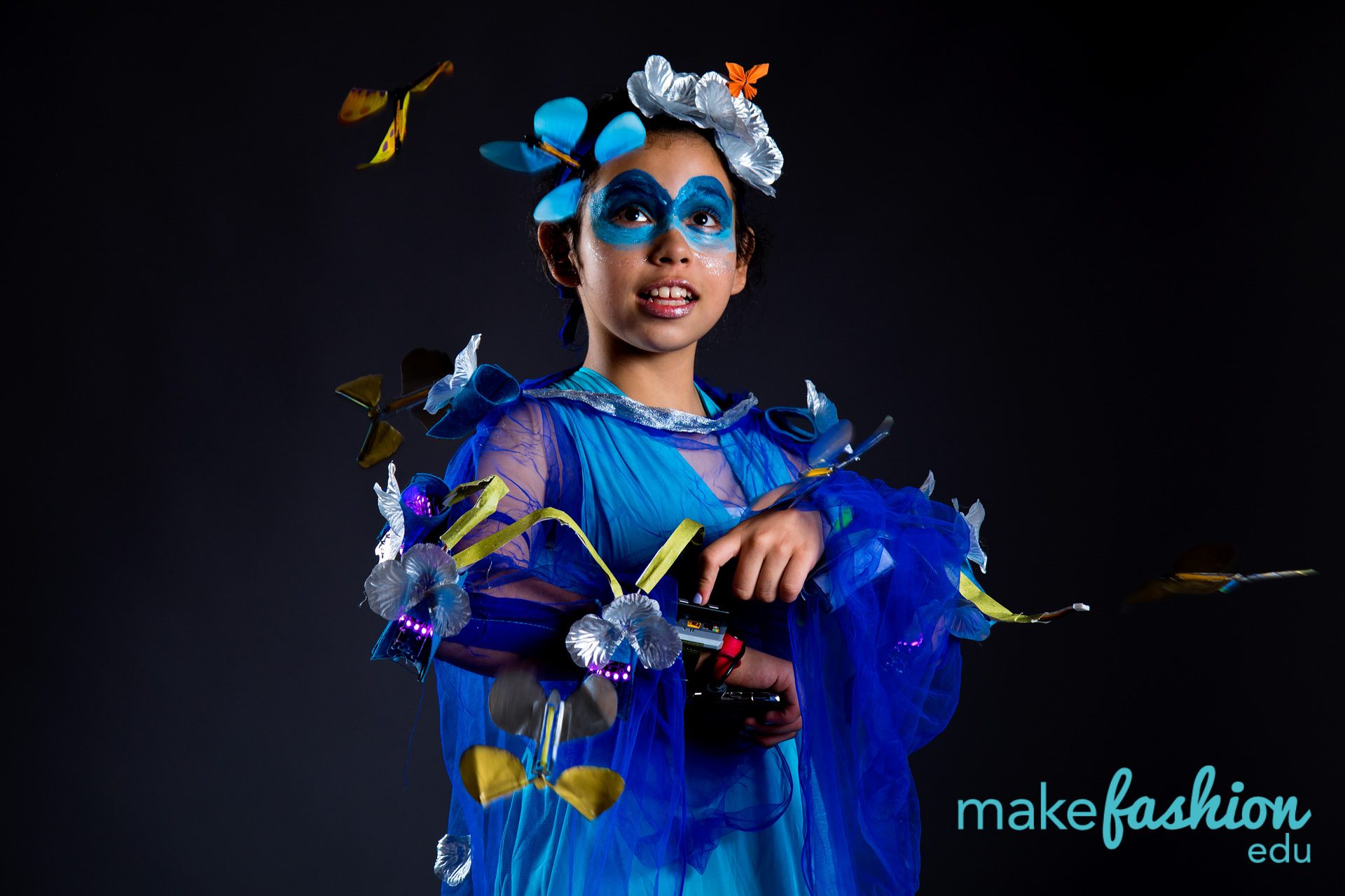 Student model in a blue tulle gown with illuminated butterfly wings