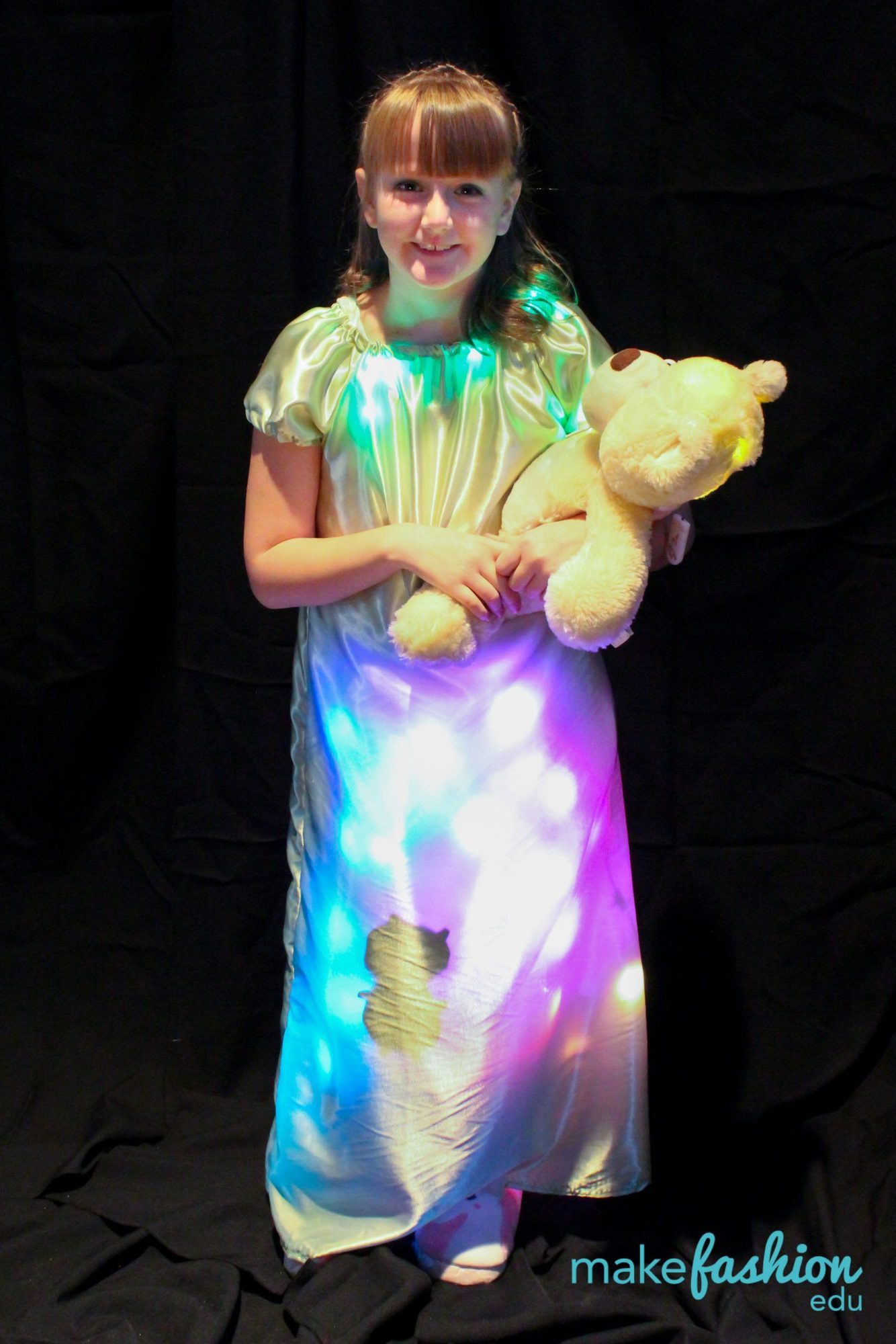 Student model in a satin nightgown with a rainbow LED-lit skirt