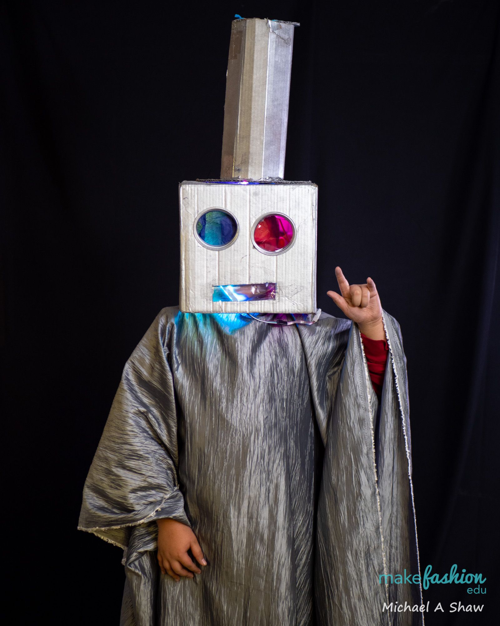 Student in boxy robot costume with glowing LED eye lenses
