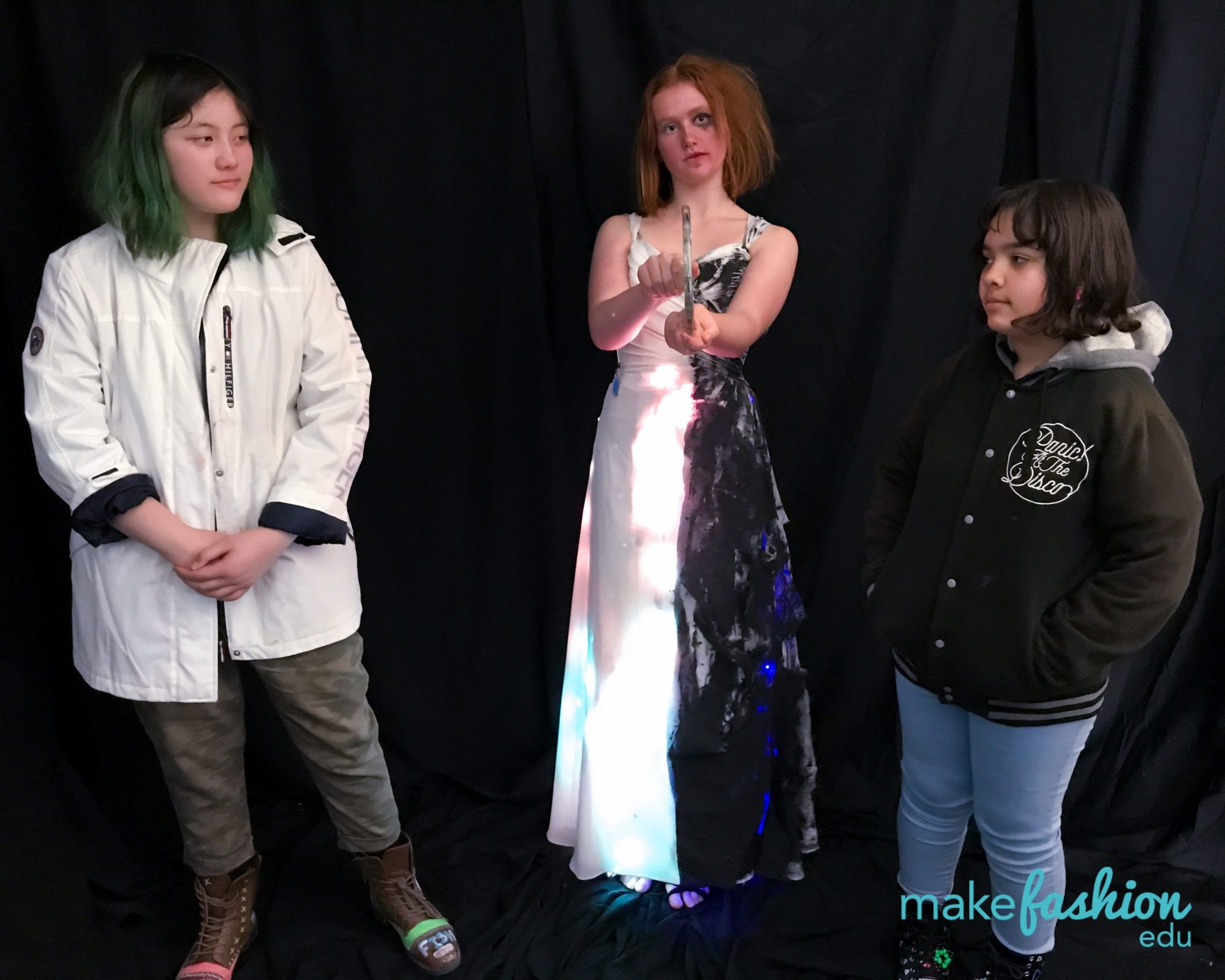 Student in a white LED-lit shirt beside a black-and-white light-up gown