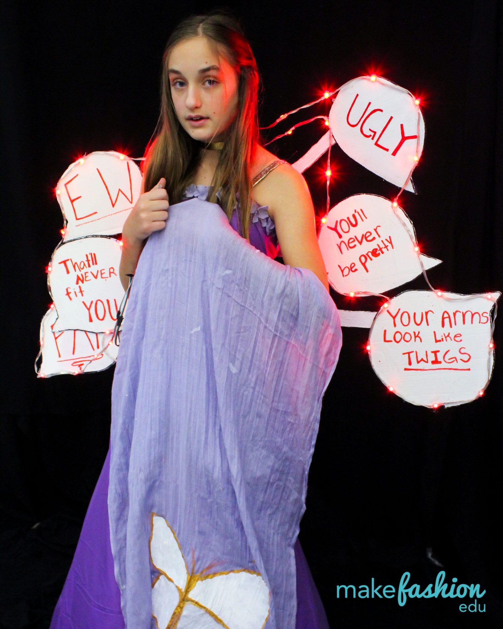 Student in a purple gown surrounded by illuminated hurtful-word speech bubbles